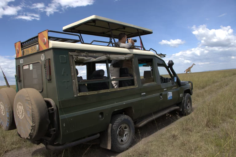 South Africa safari in October- tourist in a safari van uses his binoculars to observe wildlife