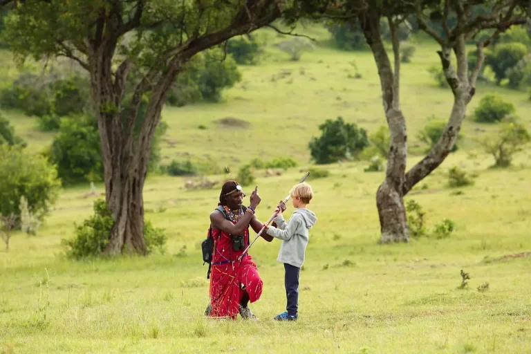 South africa safari hotels- a maia moran shows a young boy how to handle a spear