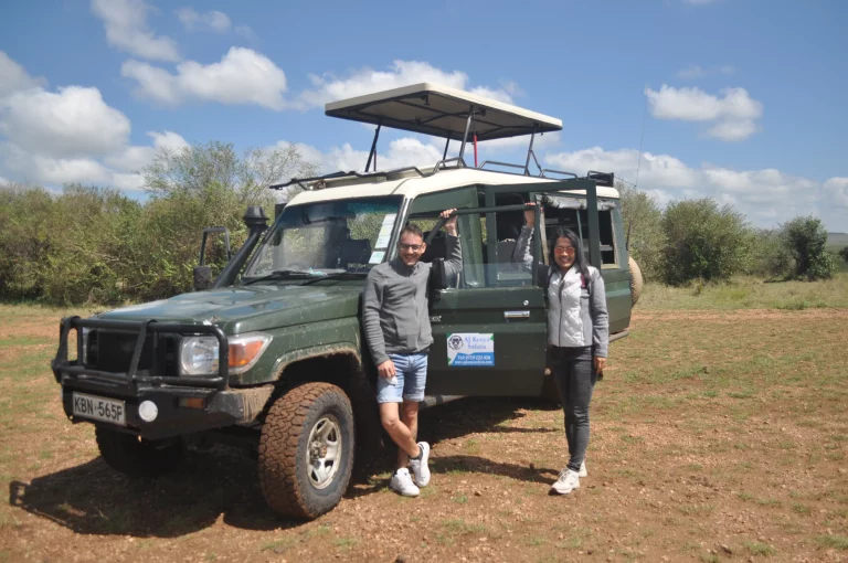 Kenya safari in august- tourists on a game drive pose for a pic outside our safari landcruiser