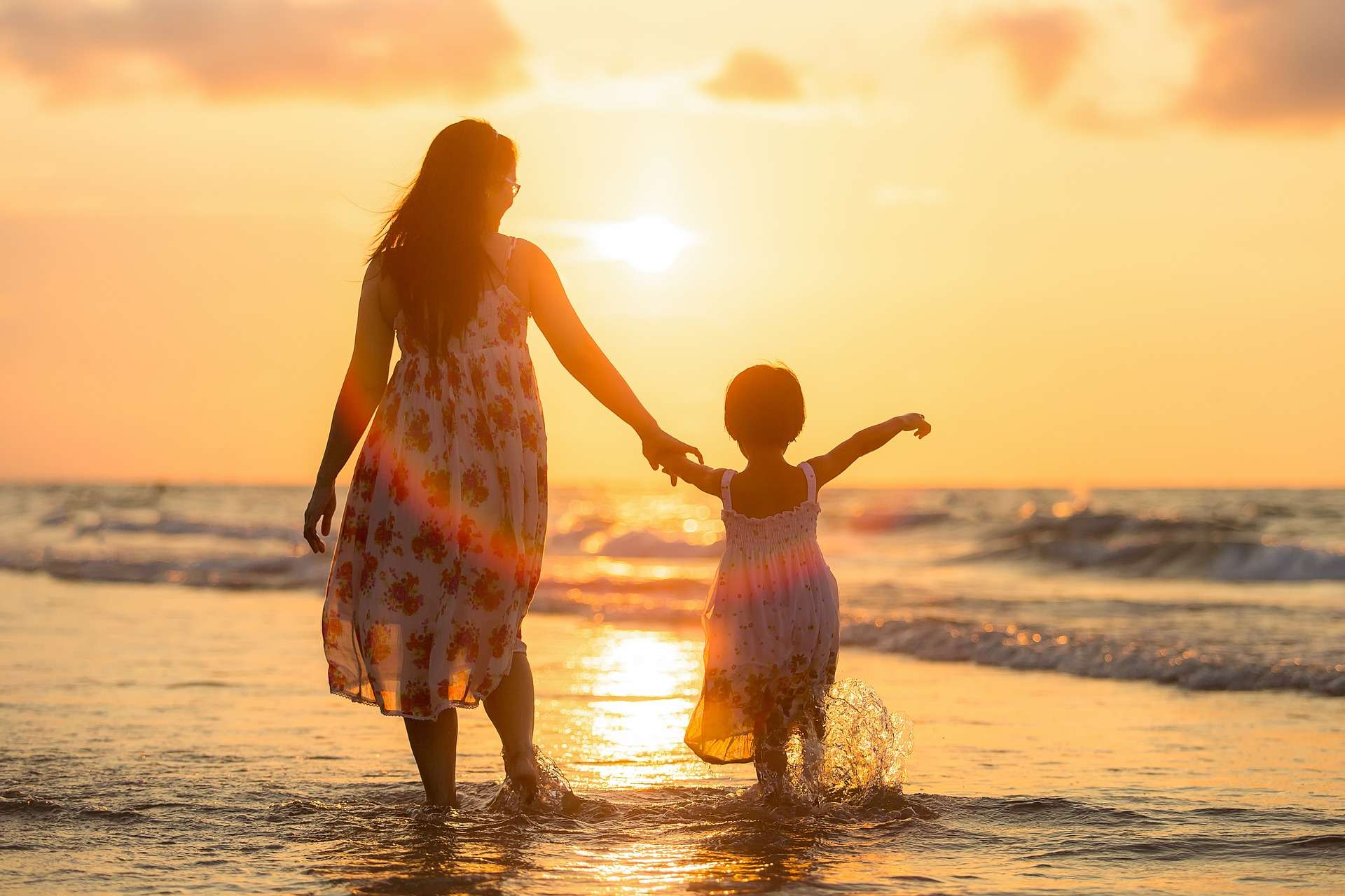 Winter sun holiday- mother and daughter on beach