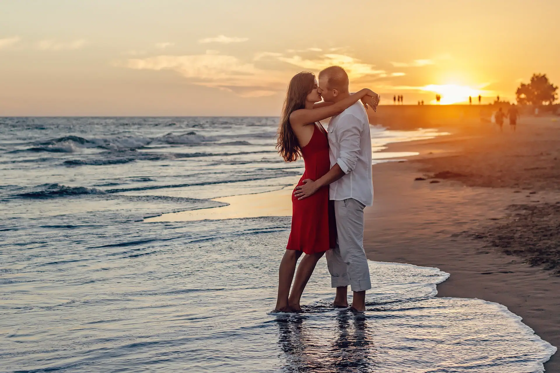 beach holiday- couple shares a kiss on the beach